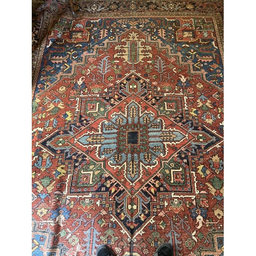 343 - A large Persian Carpet, with diamond medallion and all-over geometric designs, on iron red ground wi... 