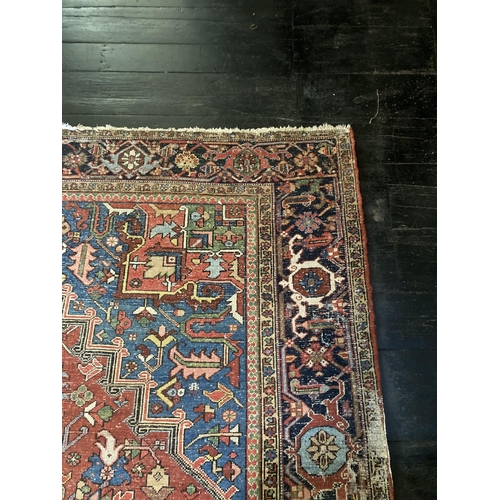 343 - A large Persian Carpet, with diamond medallion and all-over geometric designs, on iron red ground wi... 