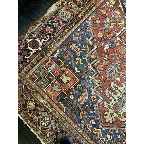 343 - A large Persian Carpet, with diamond medallion and all-over geometric designs, on iron red ground wi... 