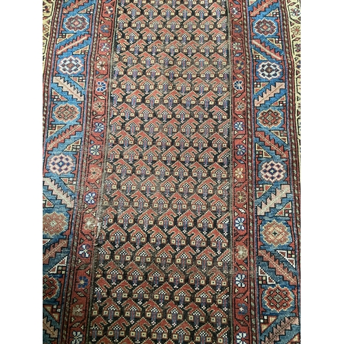 495 - A semi-antique Persian Runner, the centre panel with rows of hooked gulls, inside a multi band borde... 