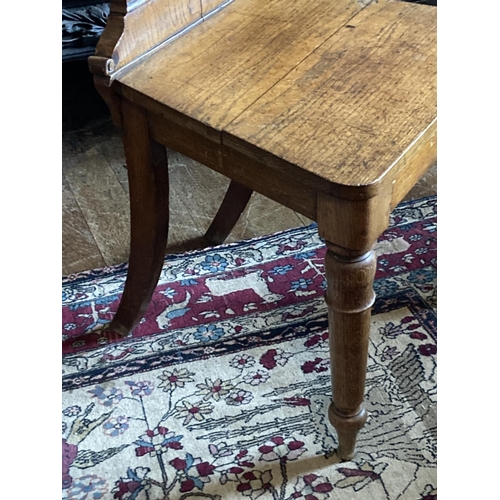 530 - A set of three Victorian heavy oak shield back Hall Chairs, the shaped and carved backs over plain s... 