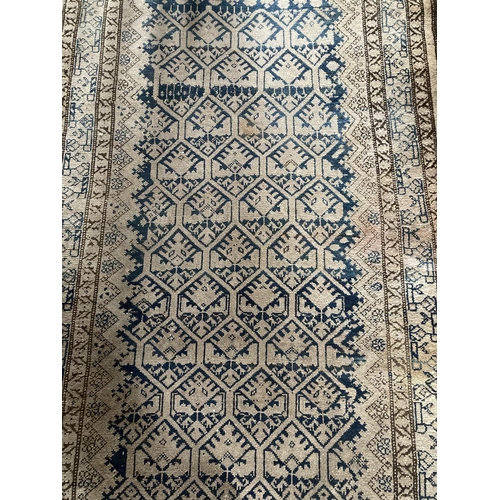 578 - An Afghan Rug, with rows of octagons on a faded ivory field with a multi banded border,approx. 10'7