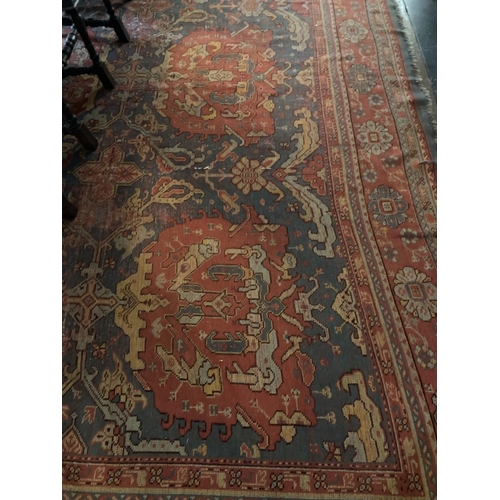 581 - A large 19th Century iron red ground and light blue Turkish Carpet, with three rows of medallions, i... 