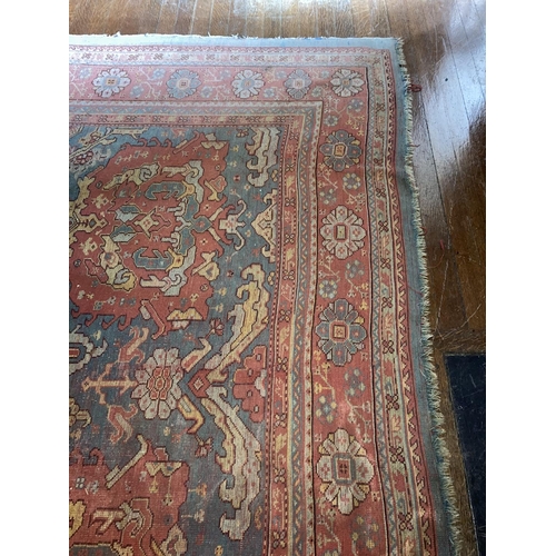 581 - A large 19th Century iron red ground and light blue Turkish Carpet, with three rows of medallions, i... 