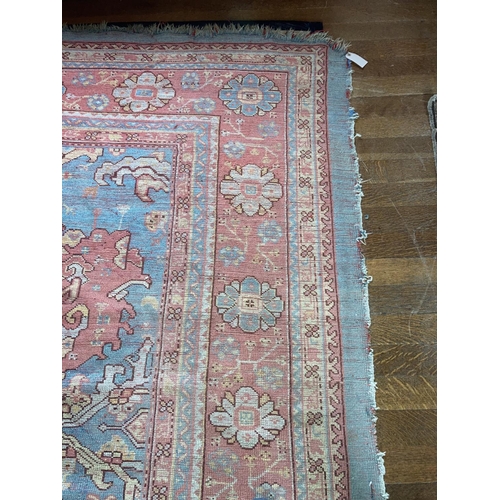 581 - A large 19th Century iron red ground and light blue Turkish Carpet, with three rows of medallions, i... 