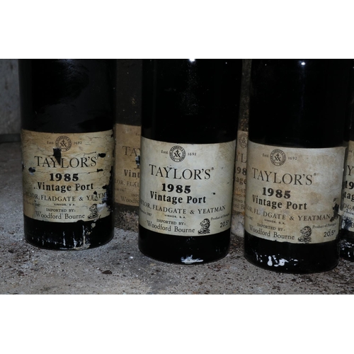 583 - Twelve Bottles of Taylors 1985 Vintage Port, (imported by Woodforde Bourne), labels worn and damp da... 