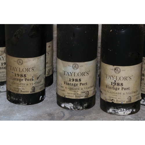 585 - Twelve Bottles of Taylors 1985 Vintage Port, (imported by Woodforde Bourne), labels worn and damp da... 