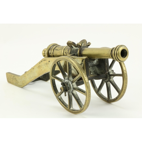 12 - A heavy brass Desk Cannon, with engraved decoration; and a tall twisted brass Candlestick, 40cms (15... 