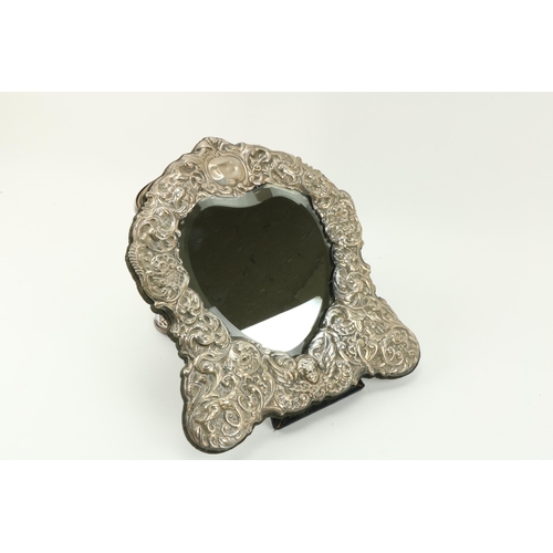 21 - An attractive modern shield shaped silver Dressing Table Mirror, with profusely embossed frame; and ... 