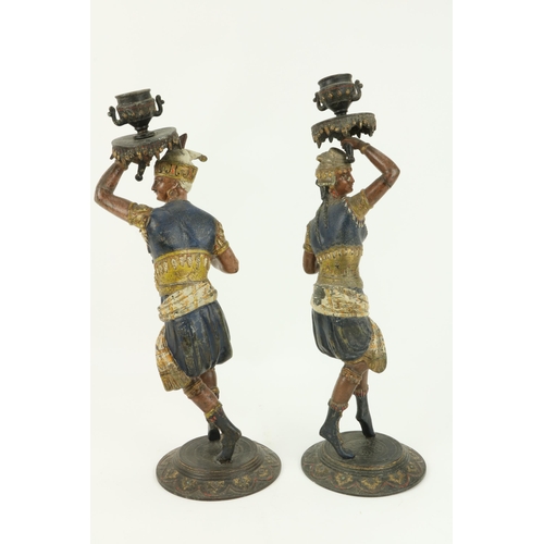 65 - An unusual pair of late 19th Century hand painted Spelter Candlesticks, each modelled as an Egyptian... 