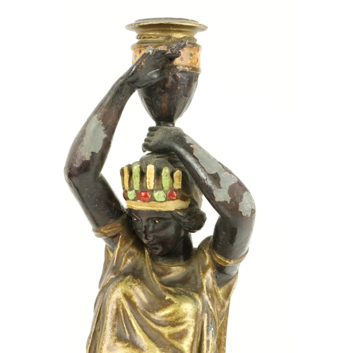 66 - An attractive pair of hand painted spelter Candlesticks, modelled as female Egyptian servants, appro... 