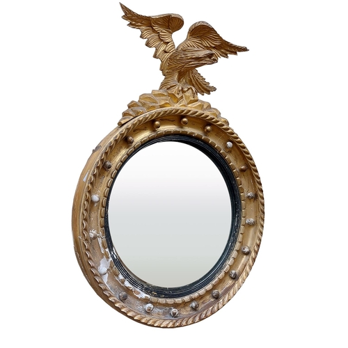 12 - A Regency period gilt convex Wall Mirror, with carved eagle crest on a ball moulded frame, 31