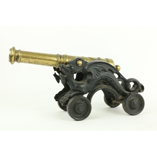 222 - A heavy brass Floor Cannon, on cast iron dragon form carriage and four cast iron wheels, 18