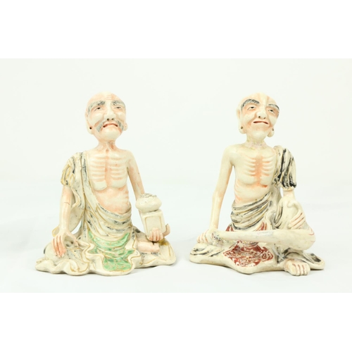 294 - A pair of 19th Century Japanese porcelain Figures, of seated Ascetic Shaman with coloured highlights... 