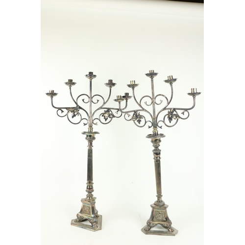 374 - A pair of tall four branch silver plated Altar Candelabra, with scrolling arms and reeded stems on t... 