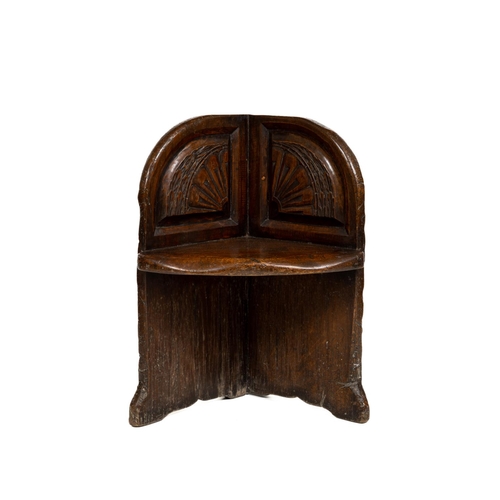 414 - A heavy early carved walnut Corner Chair, with two spandrel carved panels above a bow fronted seat. ... 