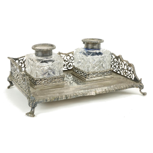 633 - A heavy English pierced silver Desk Stand, on four paw feet, with two silver mounted cutglass ink bo... 