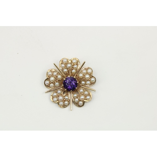 760 - An attractive gold set Brooch, modelled as a flower with central amethyst stone surrounded by multip... 