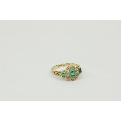 781 - An unusual 18ct gold Cluster Ring, with circle of eight diamonds and three emeralds. (1)... 