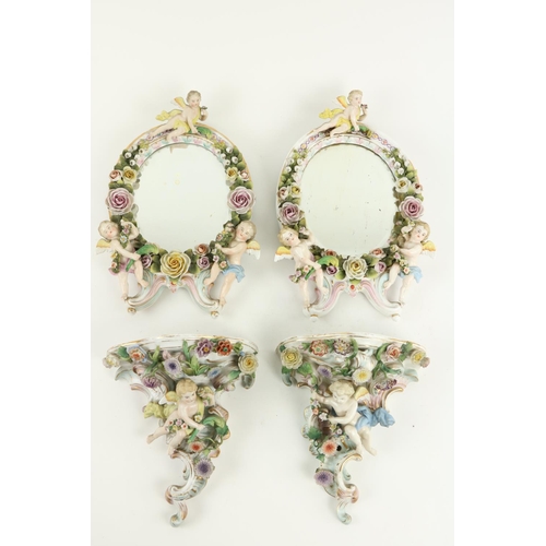 886 - A pair of oval Sitzendorf porcelain flower encrusted Table Mirrors, each surmounted with three cheru... 