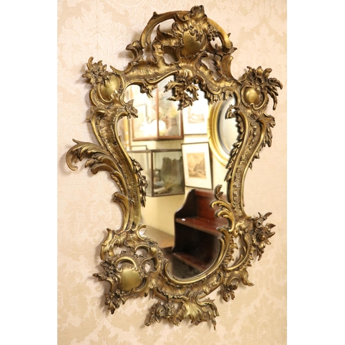 1 - A Louis XVI style shield shaped brass Mirror, of rococo design with floral bouquet and plate mirror.... 