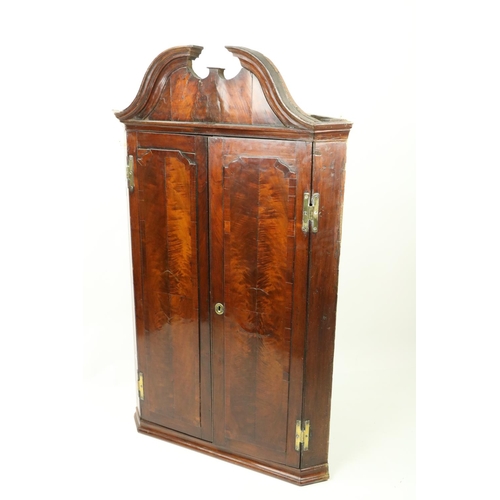 147 - A George III period mahogany Hanging Corner Cupboard, with moulded swan neck pediment above two flam... 