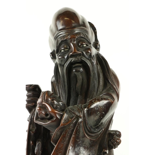 170 - A Chinese carved cherrywood Figure, of Shou Xing (God of Longevity) leaning on the 