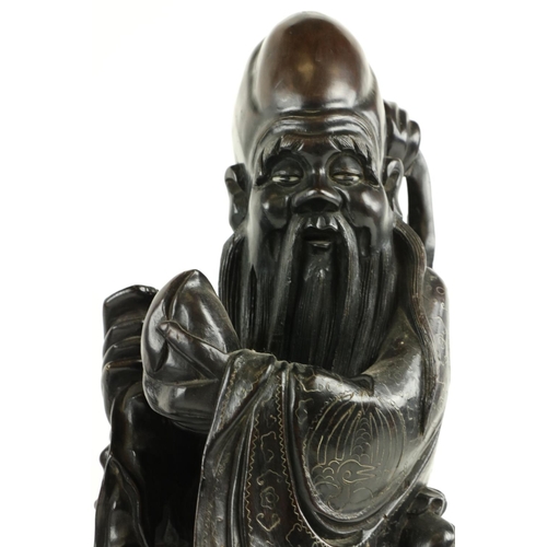 170 - A Chinese carved cherrywood Figure, of Shou Xing (God of Longevity) leaning on the 