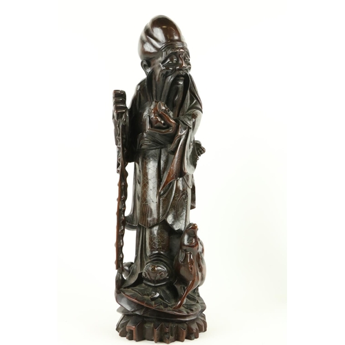 170 - A Chinese carved cherrywood Figure, of Shou Xing (God of Longevity) leaning on the 