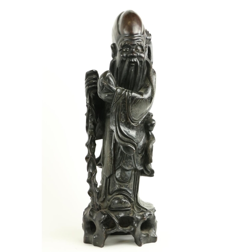 170 - A Chinese carved cherrywood Figure, of Shou Xing (God of Longevity) leaning on the 