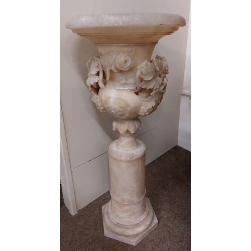 230 - A tall 19th Century vine and rose carved Alabaster Urn, with flaring neck on matching cylindrical st... 