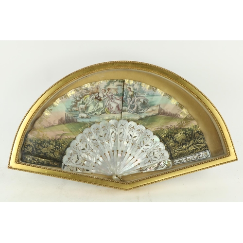 354 - An attractive framed Ladies hand painted silk and mother-o-pearl Fan, depicting Ladies resting by a ... 