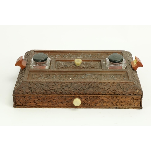 407 - A late 19th Century carved Burmese wooden Desk Stand, with two ink bottles, two pen slots and a frie... 