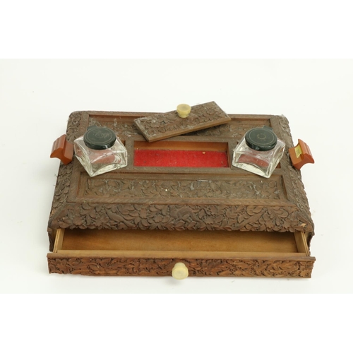 407 - A late 19th Century carved Burmese wooden Desk Stand, with two ink bottles, two pen slots and a frie... 