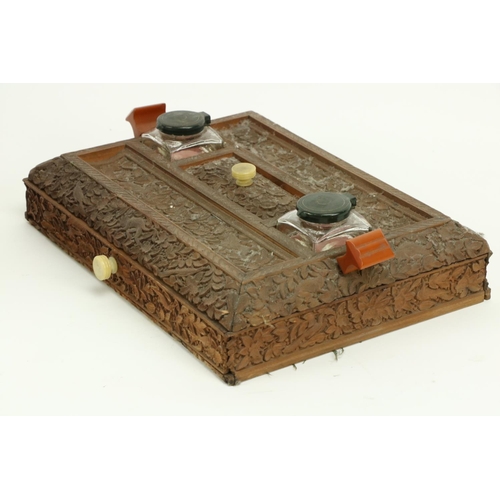 407 - A late 19th Century carved Burmese wooden Desk Stand, with two ink bottles, two pen slots and a frie... 