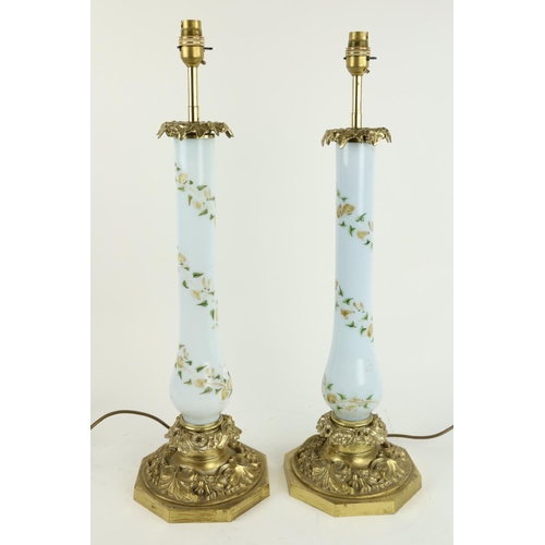 409 - A good pair of leaf cast brass Table Lamps, with light blue baluster glass stems decorated with flow... 