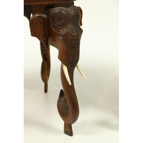 1001 - An octagonal carved teak Indian Occasional Table, with four elephant mask and tusk legs, with faux i... 