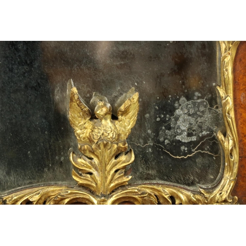 1022 - A parcel gilt and birds-eye-maple Wall Mirror, crested with a stylized leaf cartouche issuing leaf s... 