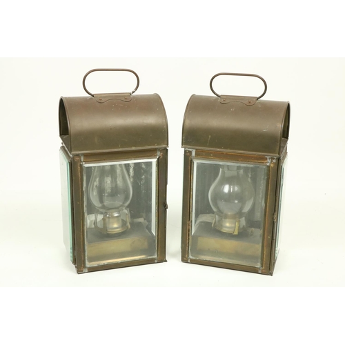 1060 - A pair of hand held or wall mounted copper Oil Lanterns, each with three glass panels, under a domed... 