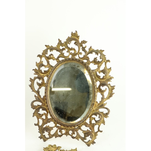 606 - A pair of tall narrow brass Wall Mirrors, each with ornate gilt brass open work frame crested with f... 