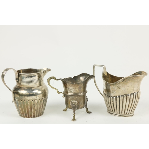 626 - Three English silver Cream Jugs, two with half reeded bodies, and one with paw feet. (3)... 