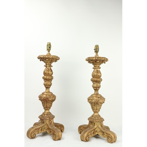 998 - A pair of composition gilt tripod Table Lamps, each moulded with leaves and grotesque masks, 25