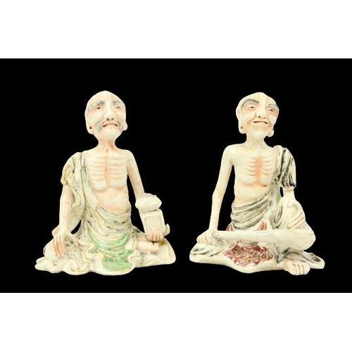 294 - A pair of 19th Century Japanese porcelain Figures, of seated Ascetic Shaman with coloured highlights... 