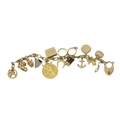 An attractive antique 9ct gold Charm Bracelet, with classic curb link gold bracelet with fourteen ch... 