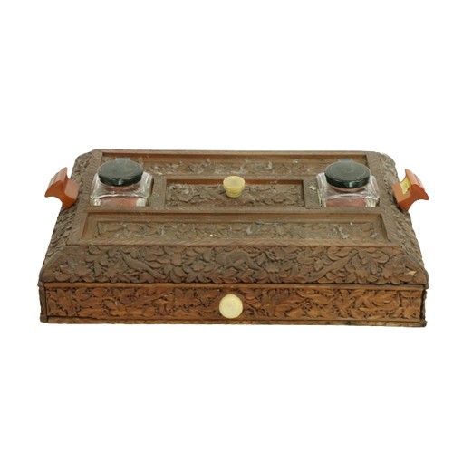 407 - A late 19th Century carved Burmese wooden Desk Stand, with two ink bottles, two pen slots and a frie... 