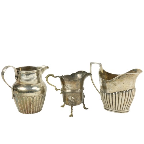 626 - Three English silver Cream Jugs, two with half reeded bodies, and one with paw feet. (3)... 