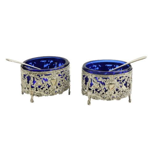 717 - A pair of oval rococo style Continental silver Salts, with blue glass liners, together with a pair o... 