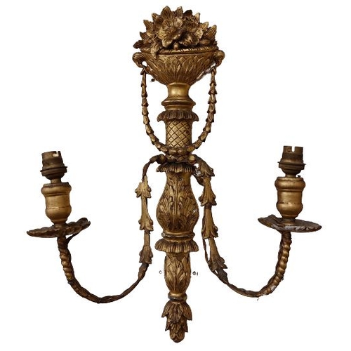 671 - A pair of carved giltwood two branch Wall Lights, each crested with a vase of flowers, issuing swags... 