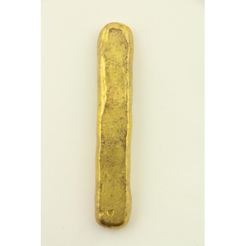 254 - A Chinese gold coloured metal Ingot, with various marks, 59grs, 8cms (3 1/4'). (1)