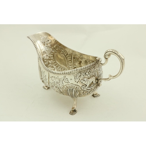 34 - A chased and embossed silver helmet shaped Cream Jug, London 1895 in the Irish 18th Century style, p... 